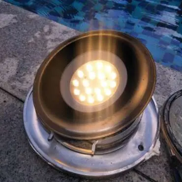 Underwater pool light removed for replacement at the pool edge