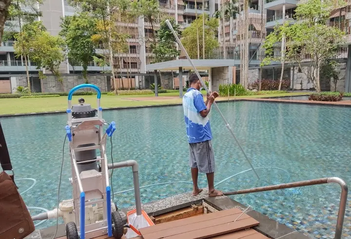 Technician operating pool-cleaning equipment