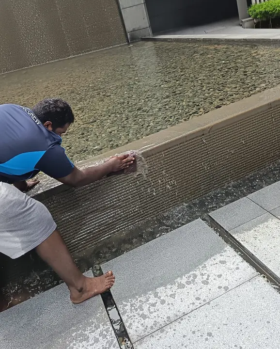 Technician cleaning residue from a drainage channel