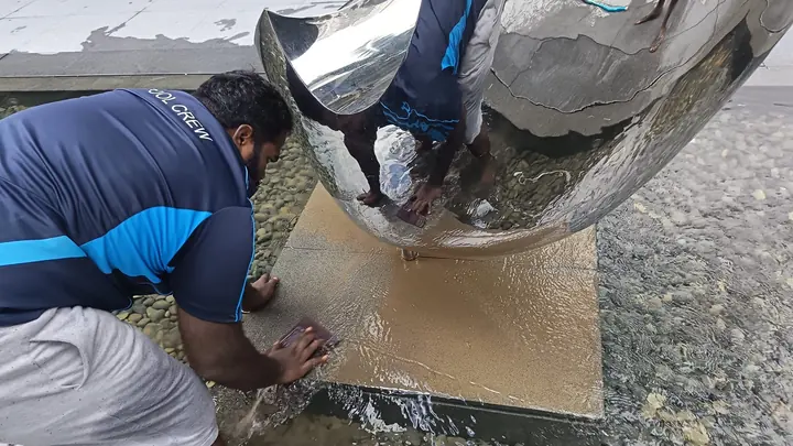 Close view of cleaning work around a rounded surface