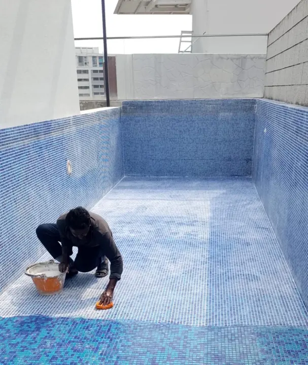 Technician working inside an emptied pool