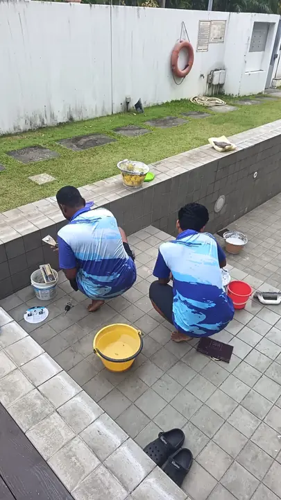 Two technicians repairing an emptied pool wall