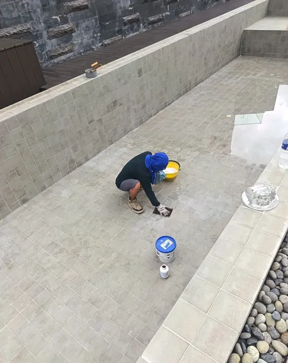 Technician carrying out repairs on an empty pool floor
