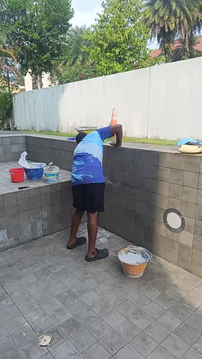 Technician repairing the wall of an emptied pool
