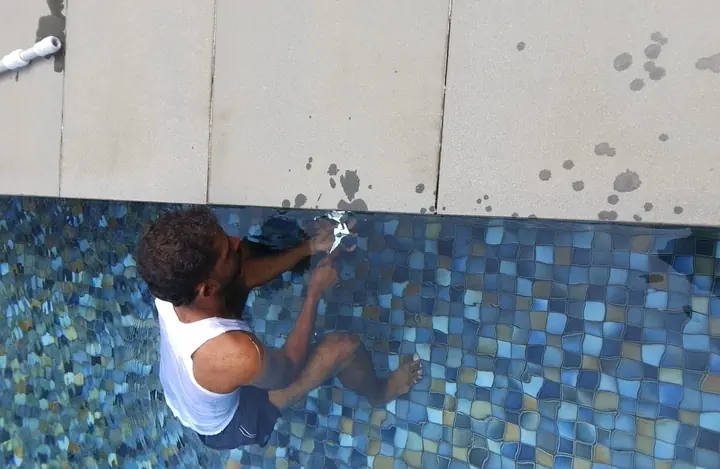 Technician removing a light beside a swimming pool