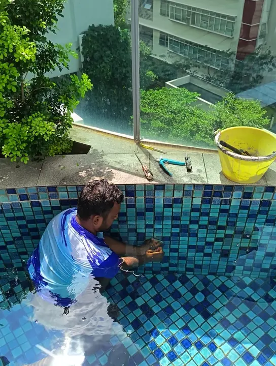 Technician working on an underwater pool-light fitting