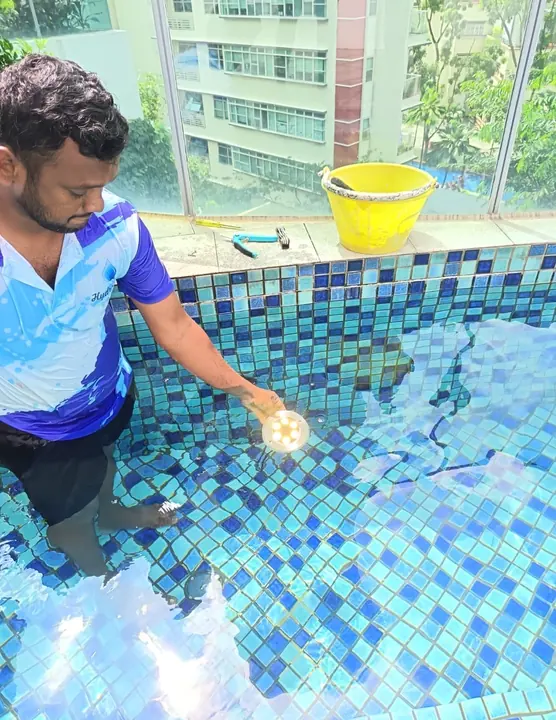 Technician testing a pool light in the water