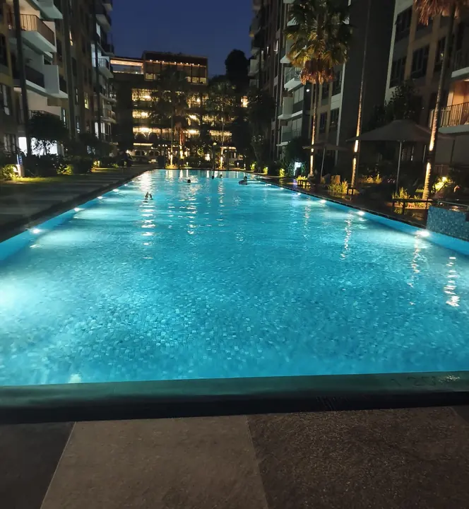 Swimming pool illuminated by underwater lights at night