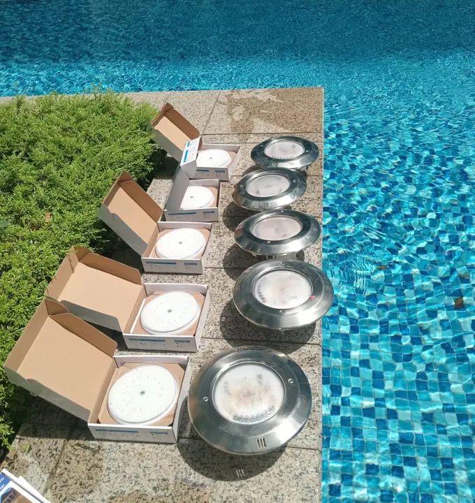 New pool-light fittings arranged beside their boxes