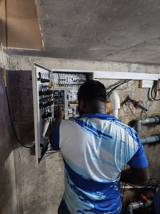Technician checking a pool equipment control panel