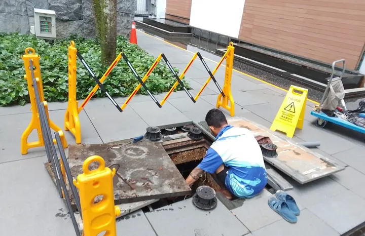Technician working inside a cordoned pump access area