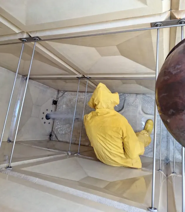Technician washing the interior of a water tank