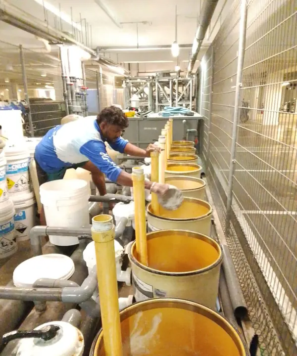 Technician working beside water treatment vessels