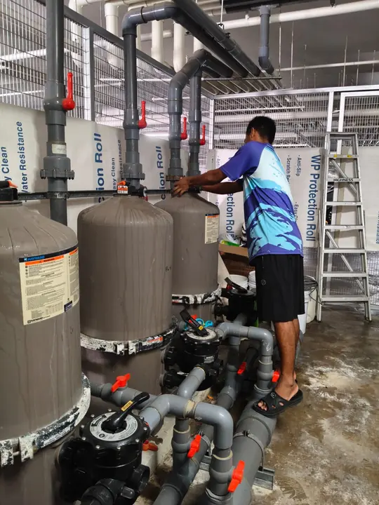 Technician checking water treatment vessels and pipework