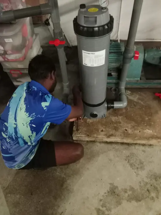 Technician servicing a cartridge filter housing